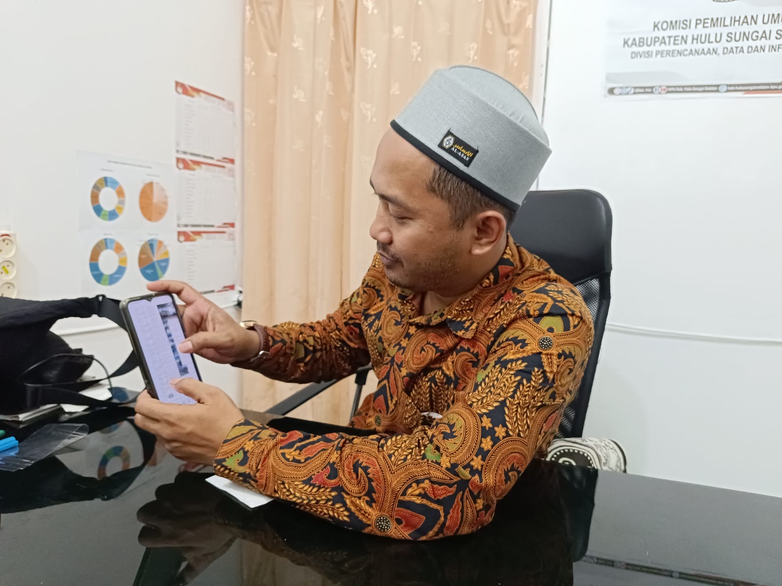 DIGESER: Anggota KPU HSS Divisi Perencanaan, Data dan Informasi, Sapari Muhammad Sidik menunjukkan rekap pergeseran TPS di Kecamatan Daha Selatan.(Foto:Salahudin/Radar Banjarmasin)