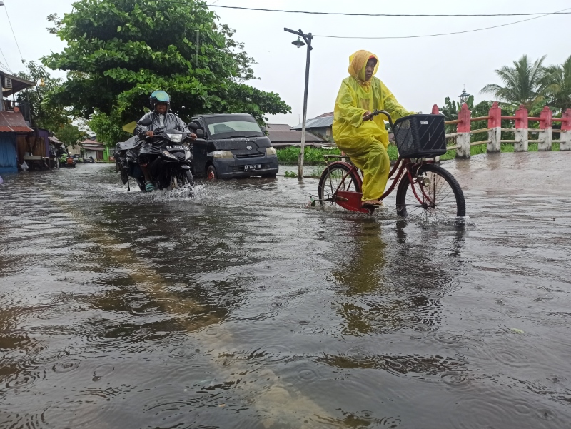TERJANG BANJIR: Warga bersepeda menerjang banjir rob yang merendam jalan di Kelurahan Pemurus Baru, Kecamatan Banjarmasin Selatan pada 4 Juli 2022 lalu.