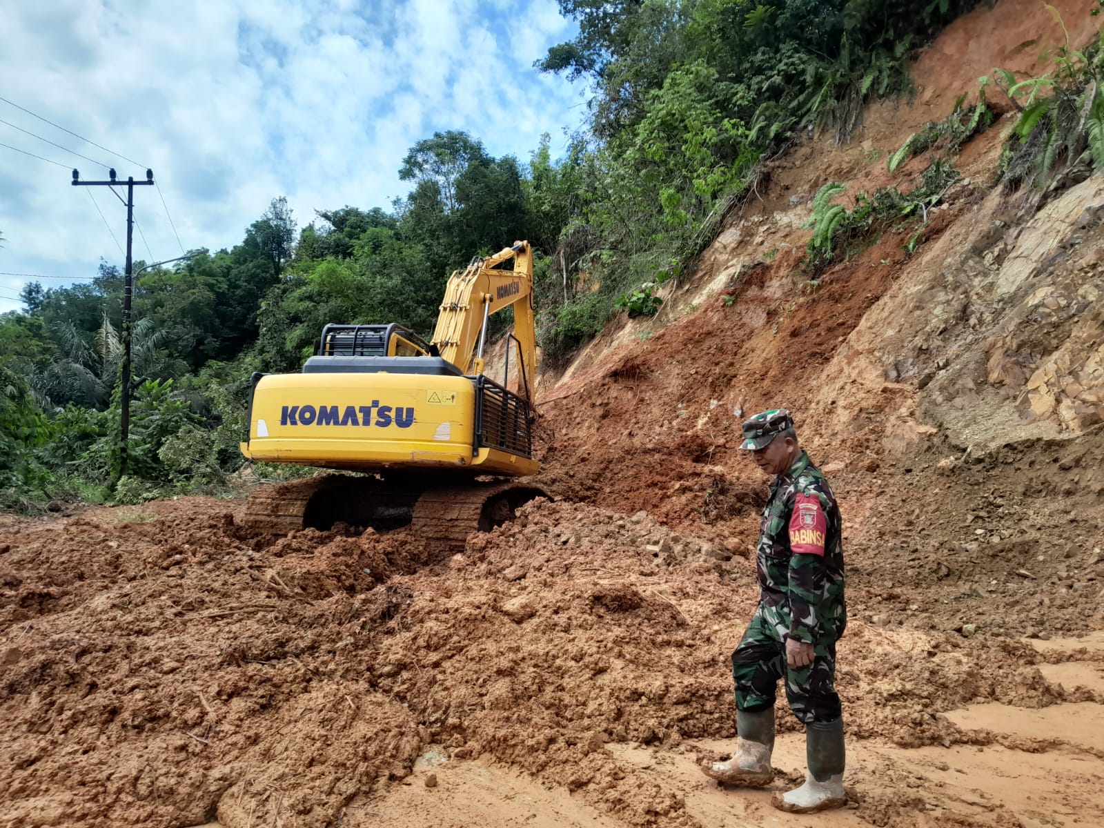 TAK BISA LEWAT: Material longsor dibersihkan menggunakan alat berat yang dikerahkan Dinas PUPR HST.
