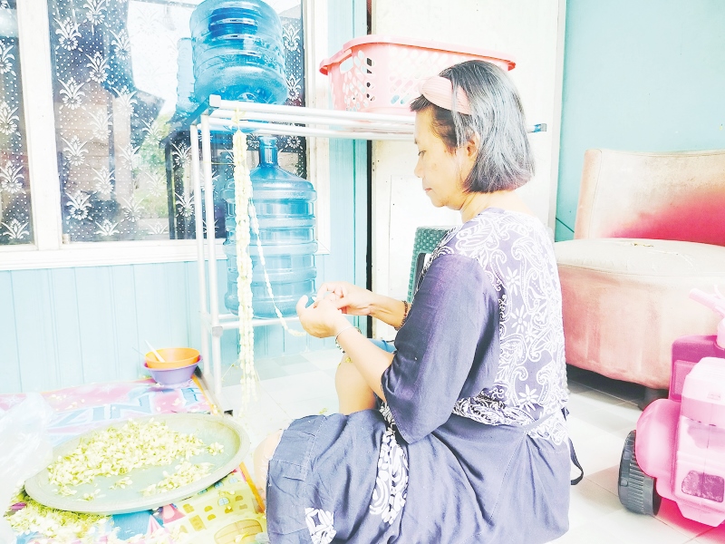 PROSES MERANGKAI: Pembuatan rumbai dari melati ini menggunakan tali rapia dan jarum dengan kesabaran dan penuh ketelitian.&nbsp;| Foto: Maulana/Radar Banjarmasin