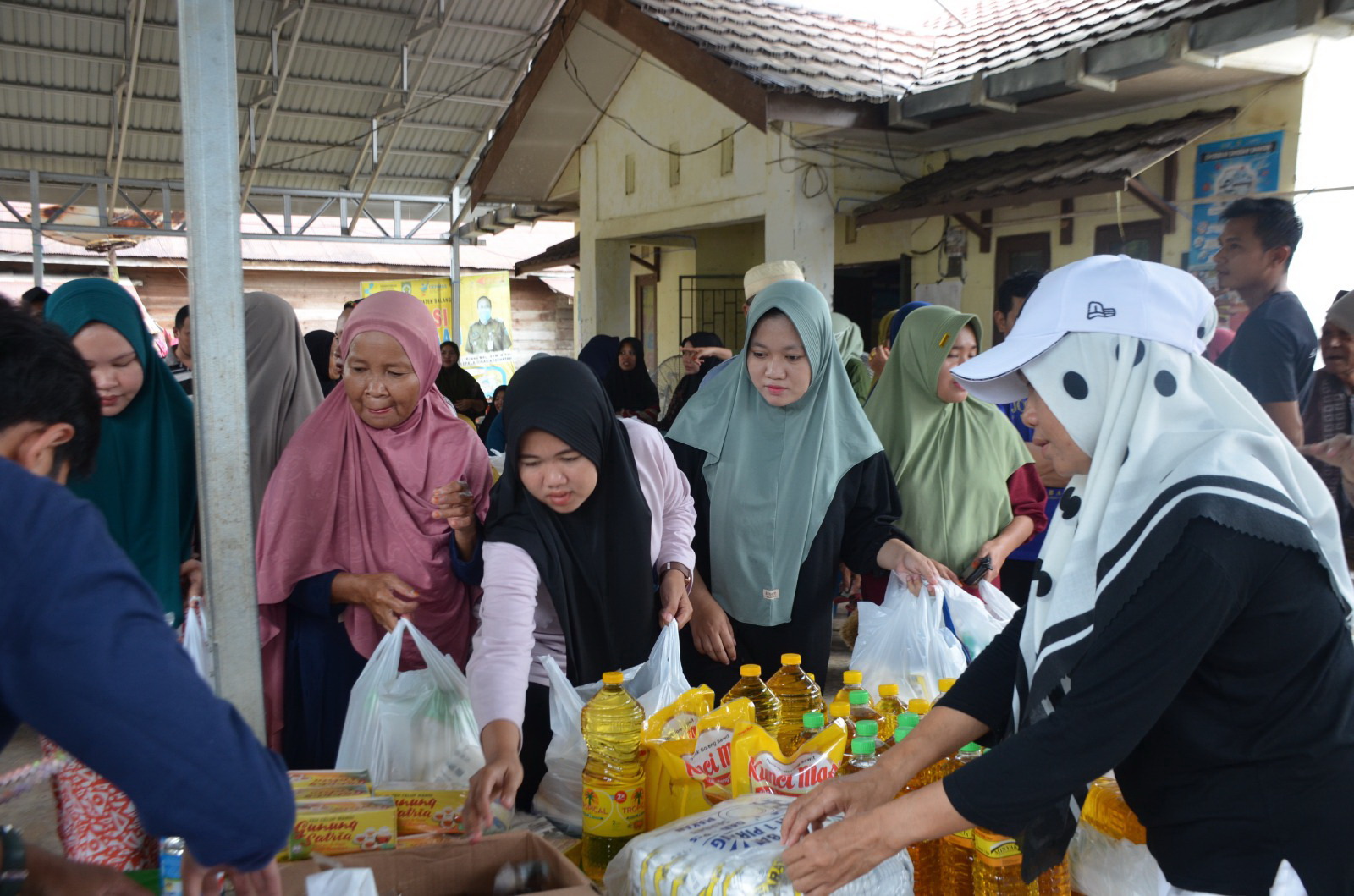 LAYANI WARGA: Petugas dari Disperindag Balangan melayani warga Pasar murah di Desa Hamarung, Kecamatan Juai, Balangan.