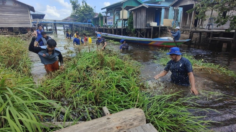 BERSIH-BERSIH: Anggota Polairud Polres HSU dan warga Kecamatan Paminggir melaksanakan aksi bersih sungai.