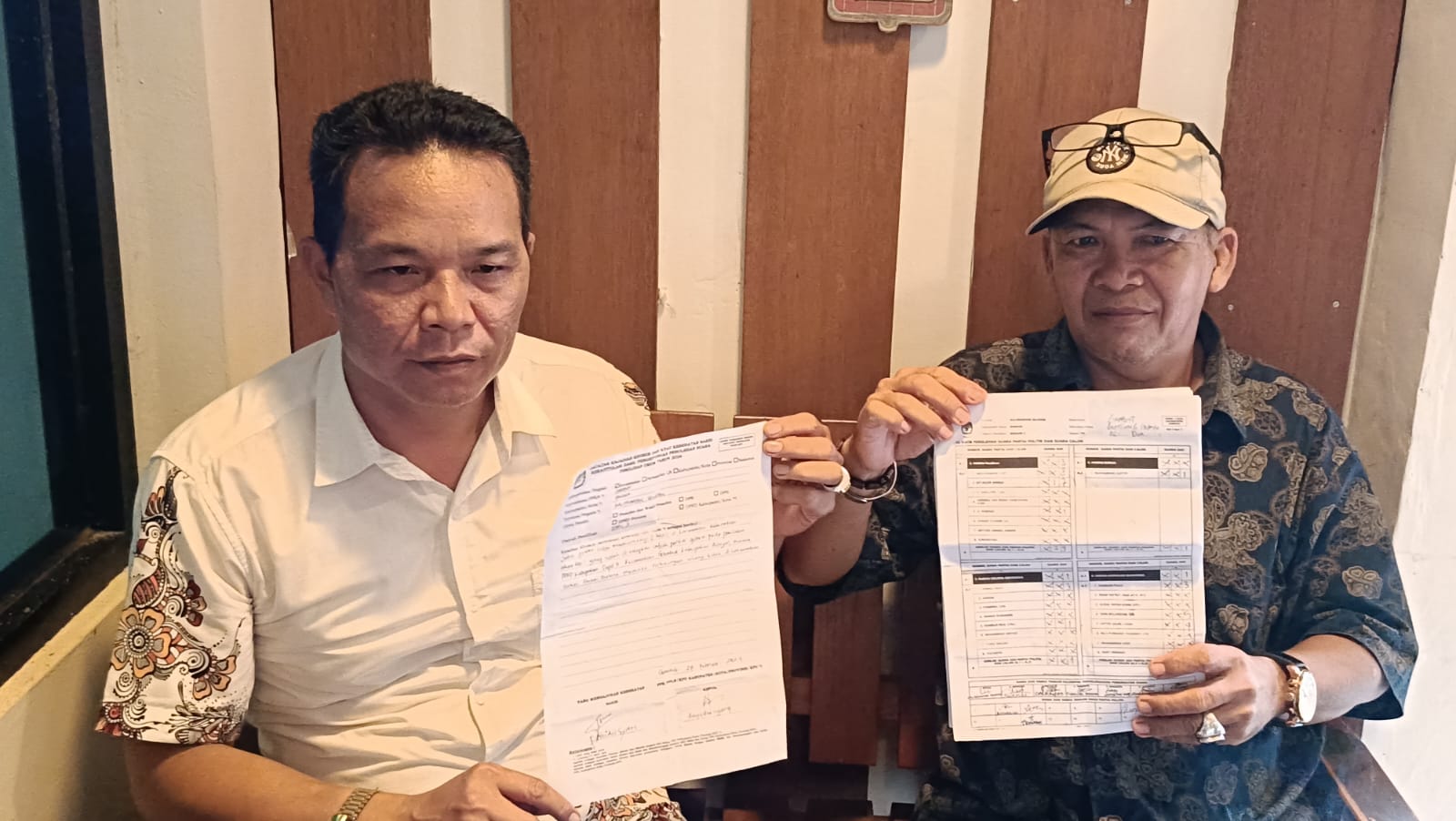 KEBERATAN:Ketua DPD Gelora Kabupaten Banjar, Ahmad Riadi menunjukan catatan kejadian khusus atas selisih suara dalam rekapitulasi hasil di tingkat Kecamatan Gambut, Kamis (29/2/2024) sore.(Foto: Sheil