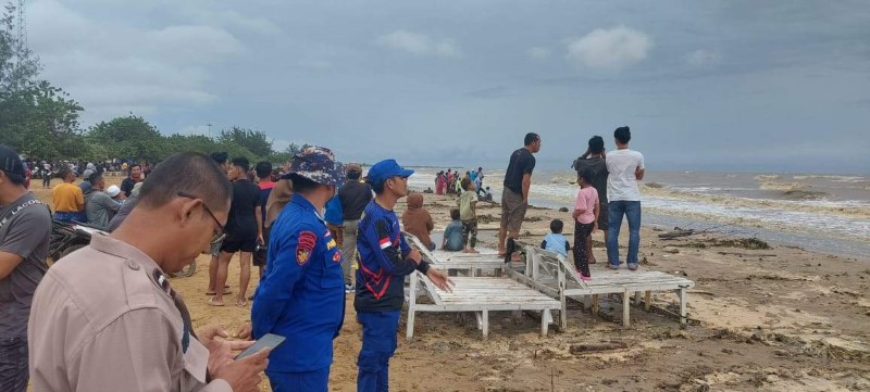 MASIH NIHIL: Personel Satpolairud Polres Tala sedang menyisir Pantai Batakan Baru untuk mencari seorang pengunjung yang terseret ombak.