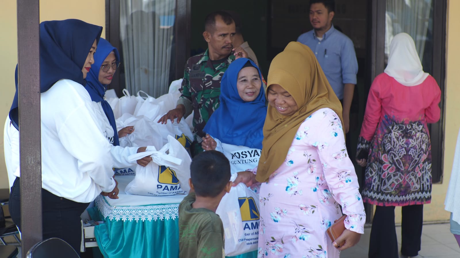 SENANG: Warga Keluarga Guntung Payung Banjarbaru sangat antusias mengambil sembako Bazar Murah PAMA Distrik BBSO di Kelurahan Guntung Payung Banjarbaru.