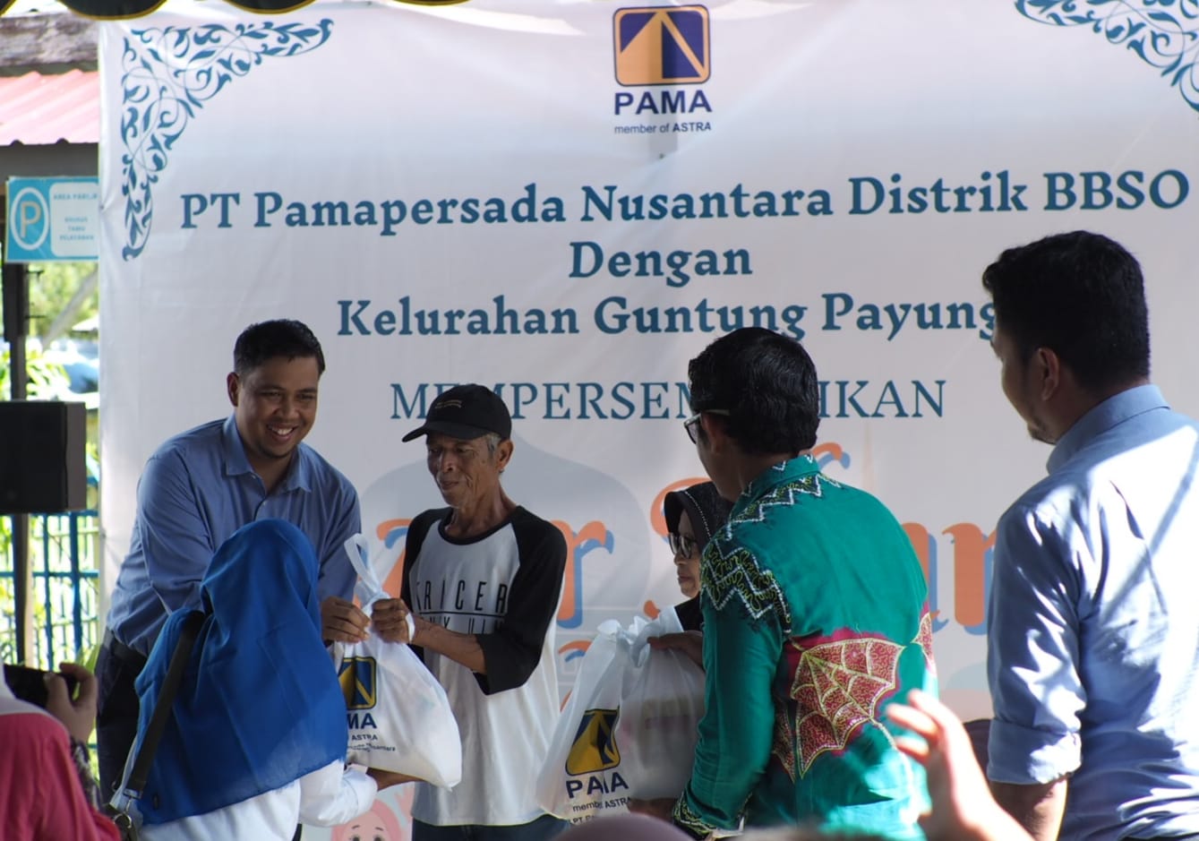 MENYERAHKAN: Head PT PAMA Distrik BBSO Arif Cahyadi saat penyerahan secara simbolis paket sembako murah kepada perwakilan warga di Kelurahan Guntung Payung Banjarbaru, Kamis (14/3).