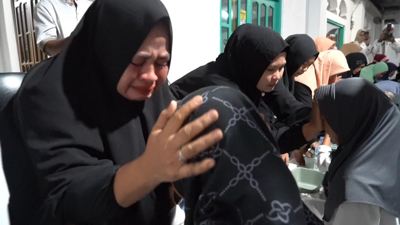 HARU: Salah seorang ibu menangis saat sang anak mencuci kakinya dalam Gerakan Cuci Kaki Ibu. -