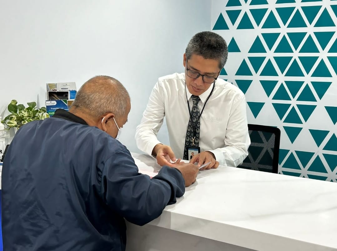 LAYANI - Dirut Bank Kalsel Fachrudin saat melayani transaksi nasabah