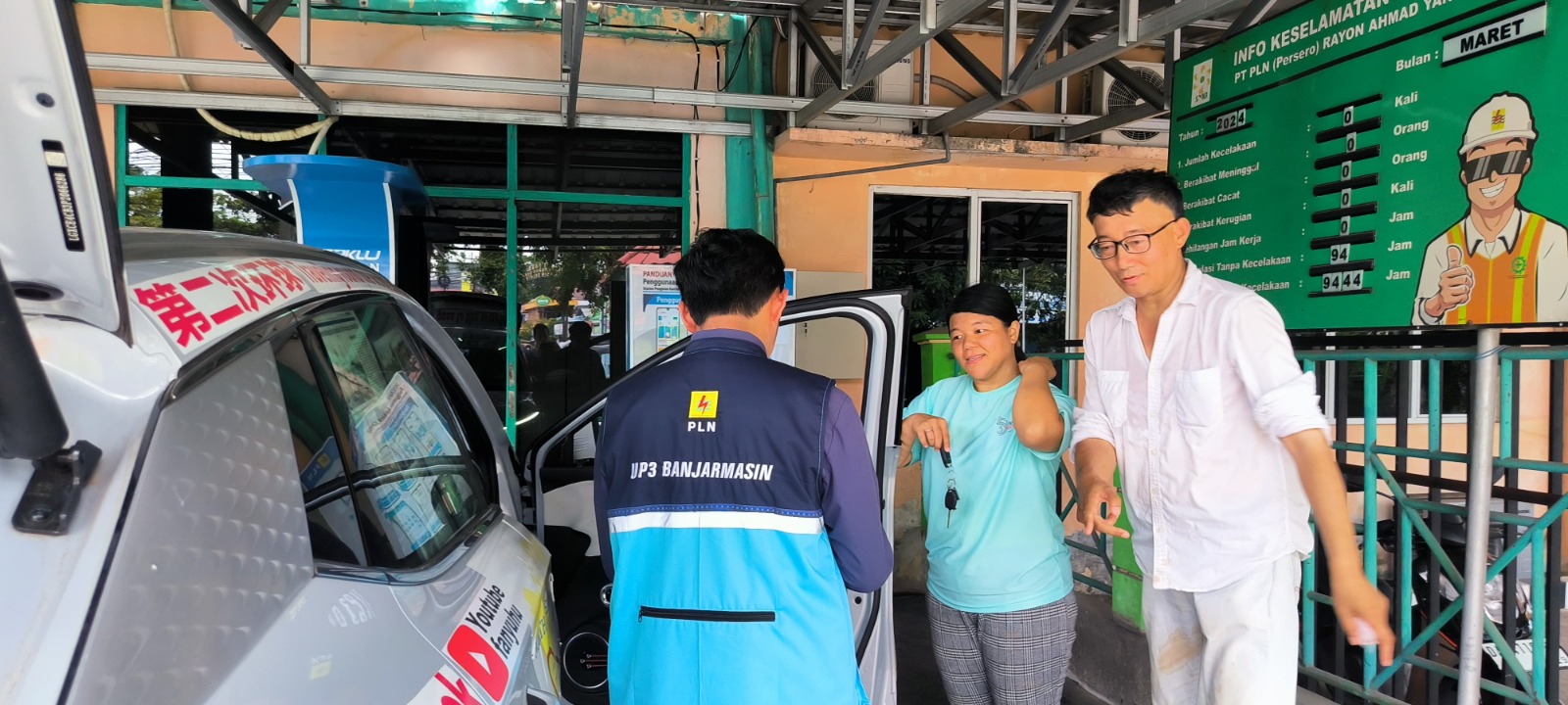 Chee Shin Yi (Miss Gloria) dan Fan Yuhu, penjelajah dunia berkewarganegaraan China dan Malaysia yang telah berkeliling dunia sejak enam bulan lalu, dibantu oleh petugas PLN