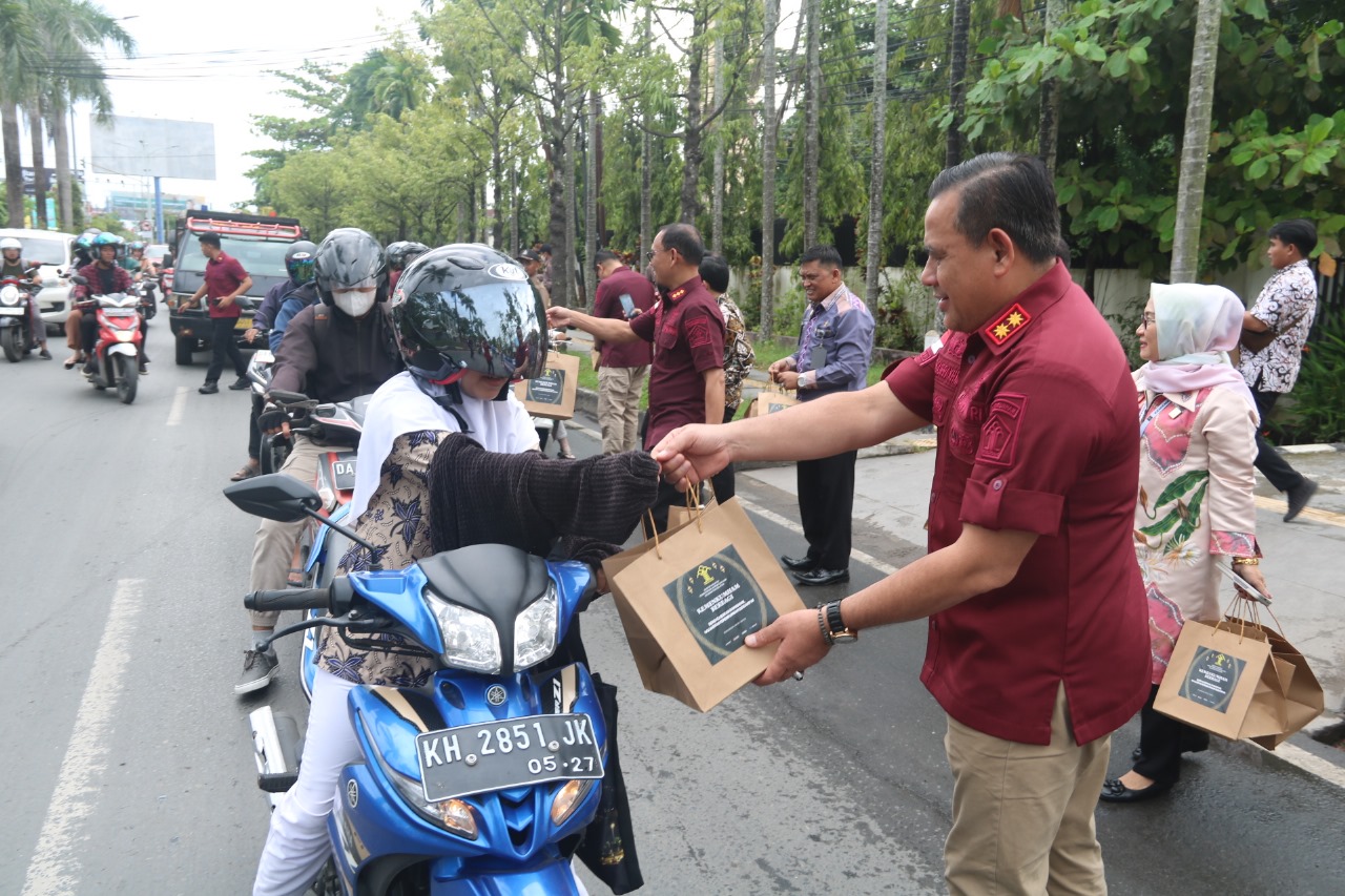 CARI BERKAH: Kakanwil Kemenkumham Kalsel, Taufiqurrakhman membagikan takjil kepada para pengendara dan masyarakat yang melintas di depan Kanwil Kemenkumham Kalsel di Kayutangi, Kamis (28/3/2024).