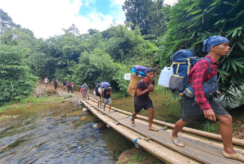 PERJALANAN DIMULAI: Dari Balai Adat Nulian di Desa Kambiayin Rt 2, Rabadi (kanan) memimpin ekspedisi menyusuri hutan menuju puncak Gunung&nbsp; Hauk, Sabtu (23/3).&nbsp;
