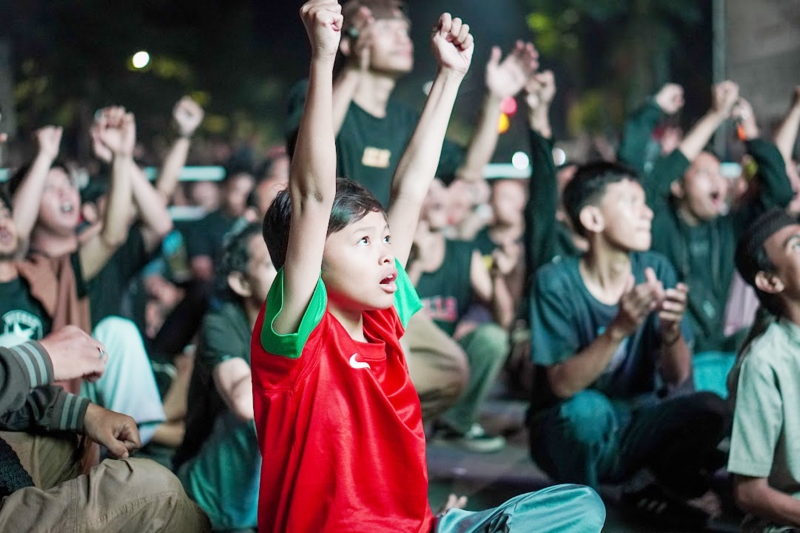 SELEBRASI: Penonton saat gol pertama tercipta pertandingan Timnas U-23 vs Korsel di videotron depan Gedung Balai Kota, Jumat (26/4) dini hari.