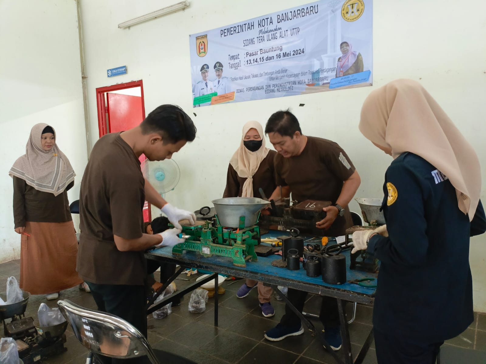 HARUS PRESISI: Petugas Diperdagin Kota Banjarbaru melakukan tera ulang ratusan Dacin milik pedagang Pasar Bauntung, Selasa (14/5/2024).(foto: Fadlan Zakiri/Radar Banjarmasin)