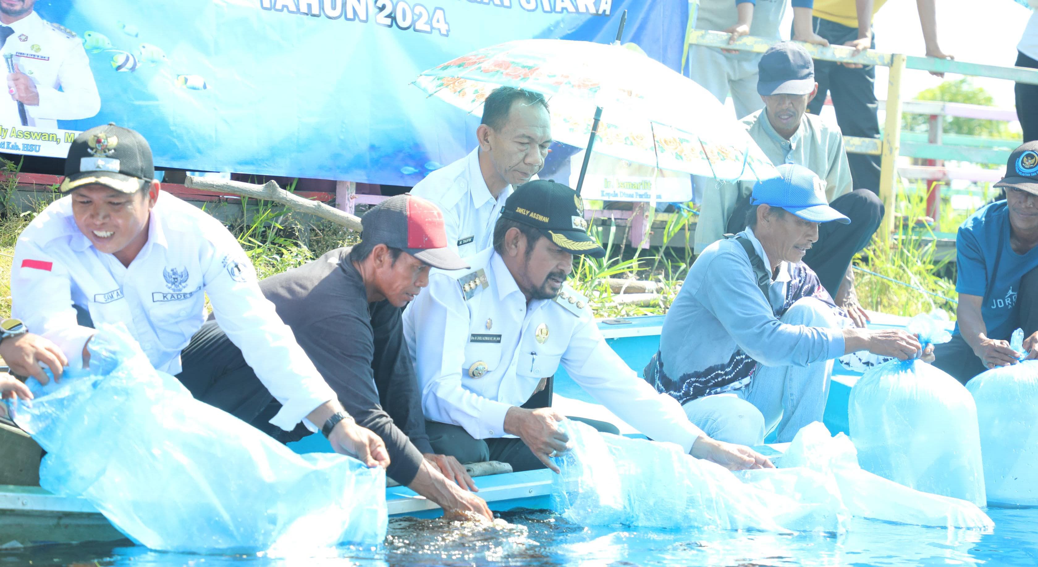 PELEPASAN: Dinas Perikanan HSU melepas ribuan anak ikan air tawar di Desa Tampakang, Paminggir.