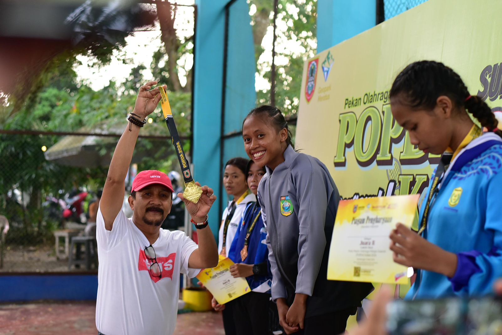 JUARA: Pj Bupati Tala H Syamsir Rahman mengalungkan medali emas kepada atlet tinju Tala yang meraih emas Syairatul Rahmi.