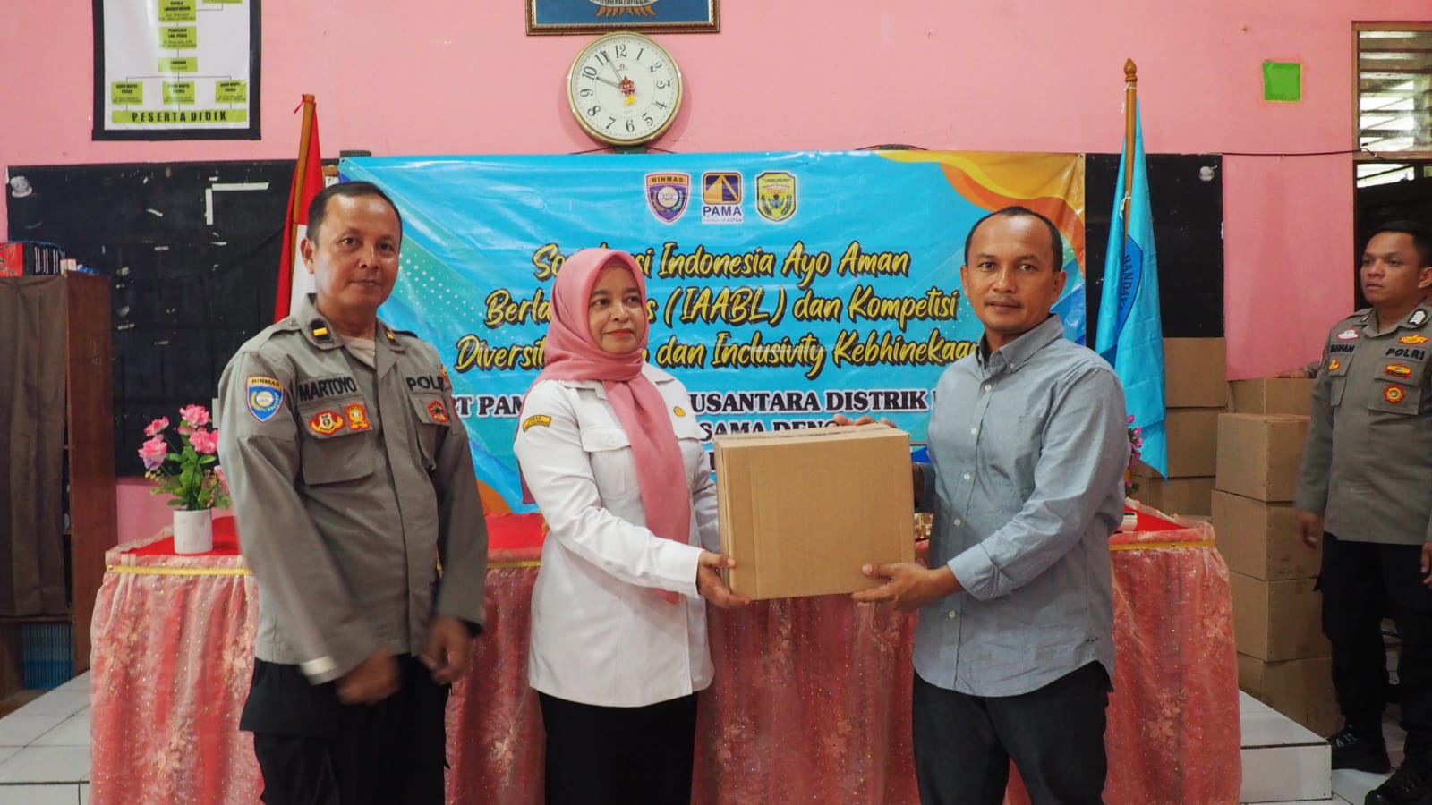 MENYERAHKAN: Prihadi Suseno (kanan) dan Ipda Martoyo (kiri) saat menyerahkan secara simbolis bantuan berupa helm kepada Kepala SMAN 3 Banjarbaru. Rahmah MPd (tengah)