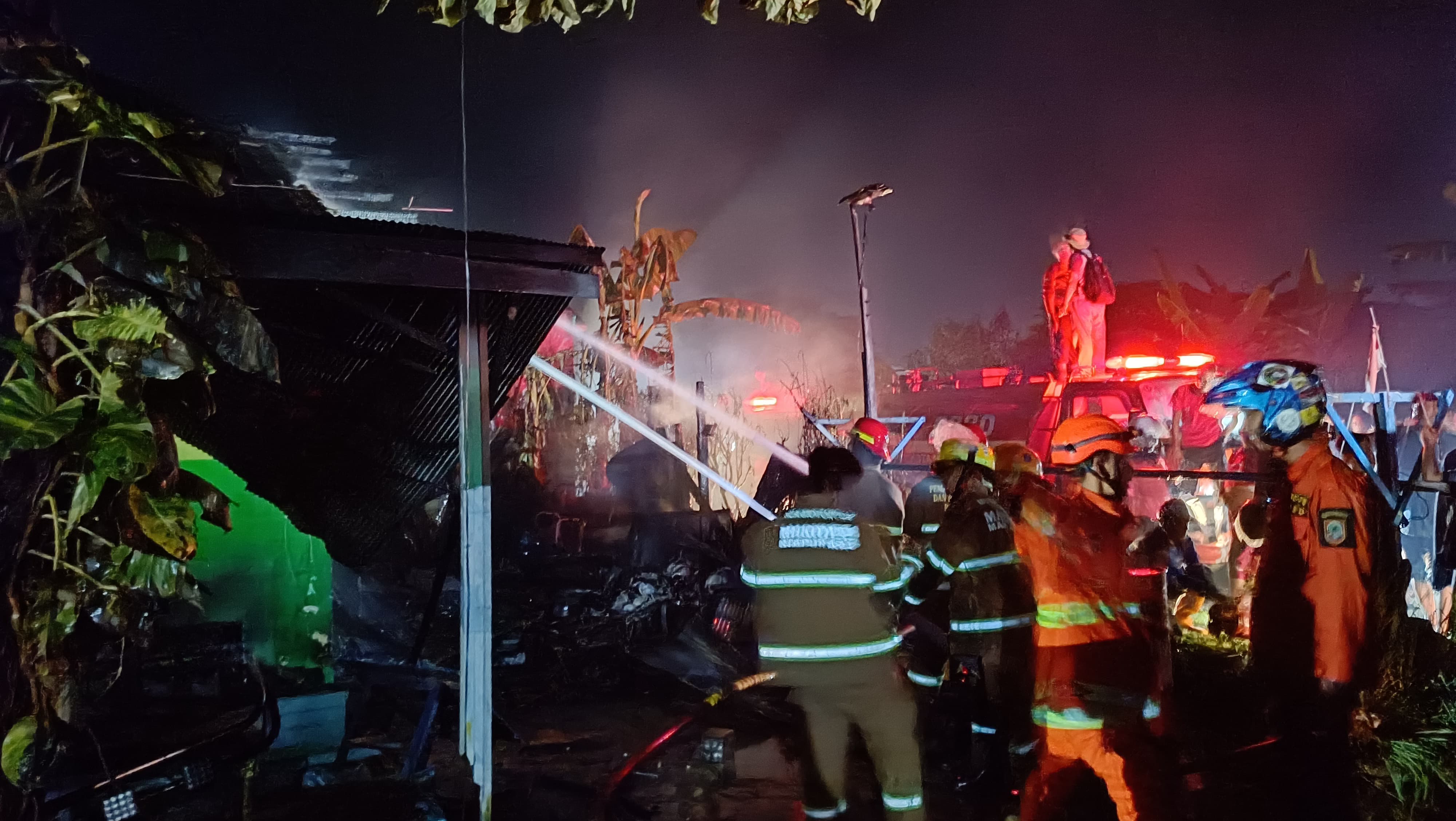 PEMADAMAN:Sejumlah relawan pemadam kebakaran (damkar) berjibaku memadamkan api di Komplek Berlina Jaya 3, Guntung Manggis, Banjarbaru, Senin (10/6/2024) malam.(Foto:Sheilla Farazela/Radar Banjarmasin)