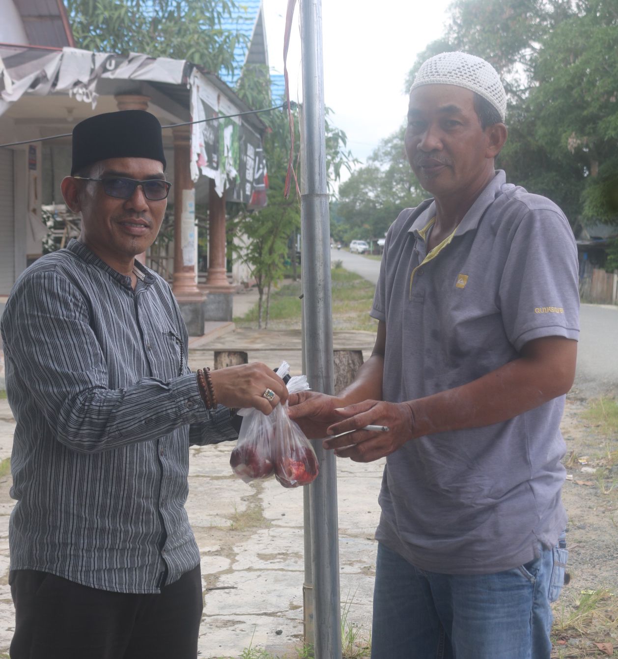 SENANG: Arbani Anggota DPRD Kotabaru langsung bagikan daging hewan yang di Qurbankannya.  | Foto: Jumain/ Radar Banjarmasin.