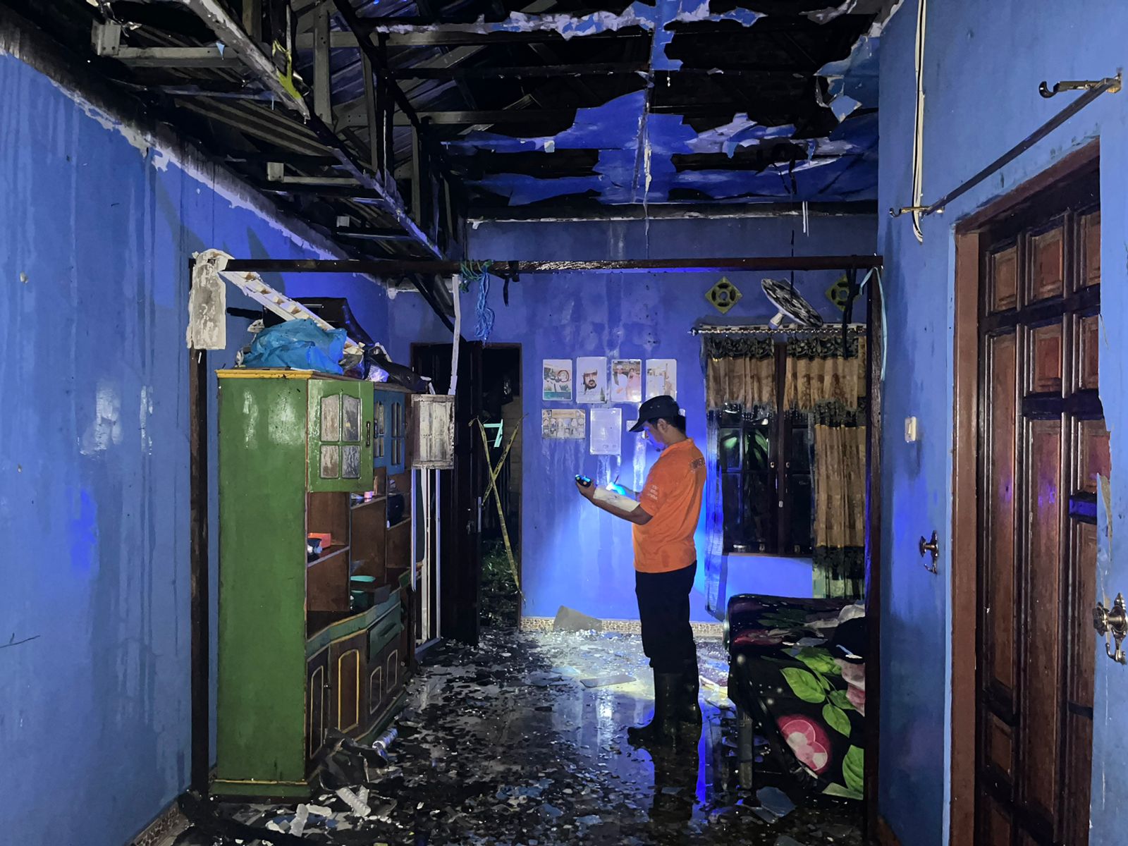 OLAH TKP: Personel Inafis Polres Hulu Sungai Utara menyelidiki rumah milik Liani yang terbakar di RT 12 Kelurahan Sungai Malang, Selasa (18/6/2024). (Foto: M.Akbar/Radar Banjarmasin)