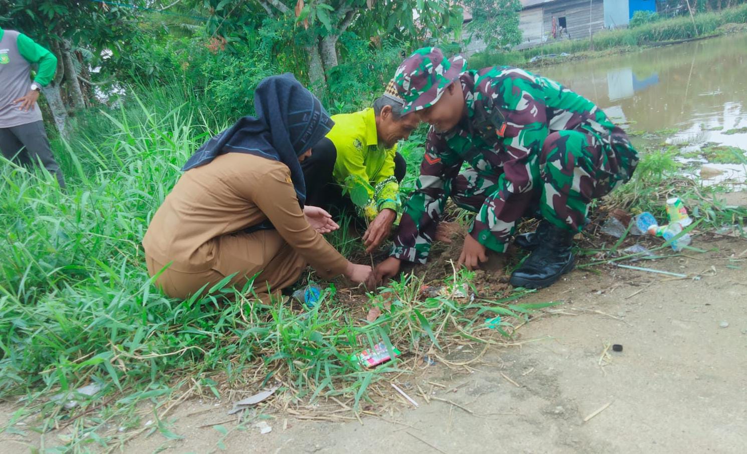 AKTIVITAS: Proses penanaman pohon di Kecamatan Amuntai Selatan, digelar Koramil Amuntai Selatan bersama warga dan aparat desa. (Foto: M.Akbar/Radar Banjarmasin)