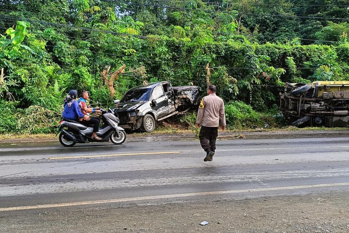 MAKAN KORBAN: Personil Polsek Bati-Bati melakukan pengamanan lalu lintas di lokasi kecelakaan di Desa Nusa Indah.