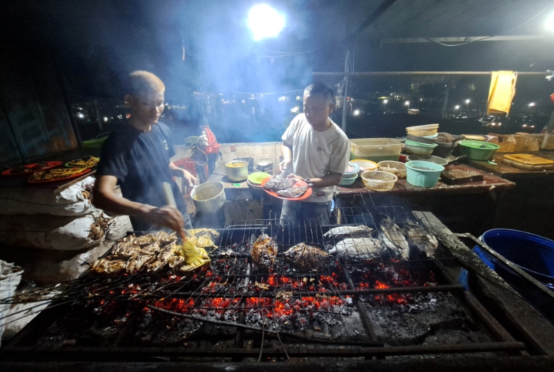 MENGGUGAH SELERA: Ilyas dan Yadimembakar ikan di foodcourt Pasar Ikan Modern (PIM) di Jalan Muara Baru, Penjaringan, Jakarta Utara.