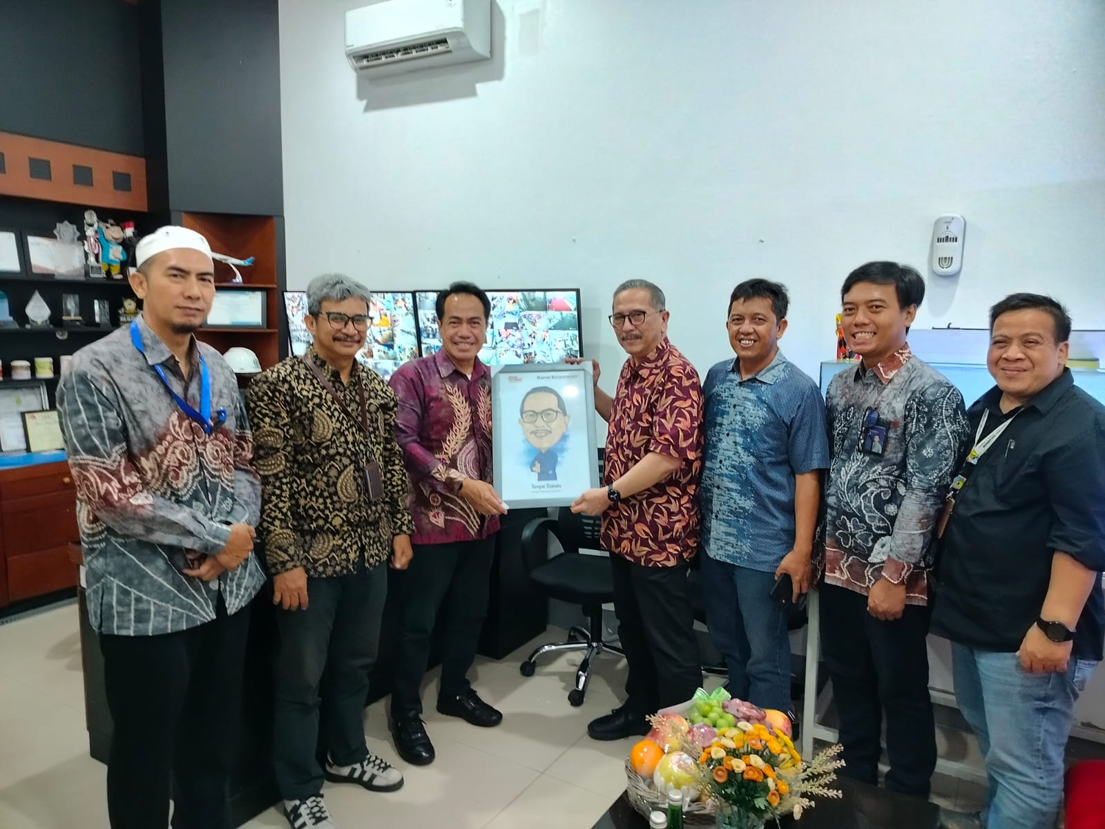 KEJUTAN:Direktur Utama Radar Banjarmasin Suriansyah Achmad menyerahkan karikatur kepada GM Duta Malla Tumpal MP Silalahi.