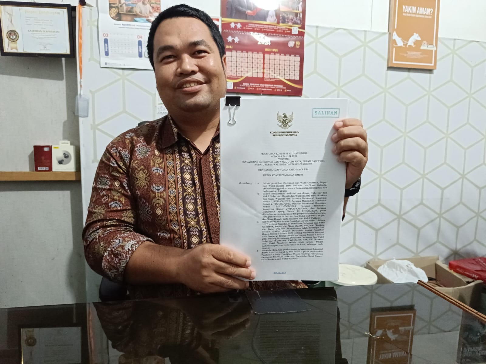 TUNJUKKAN:Anggota KPU HSS Divisi Teknis Penyelenggaraan, Padilaturrahman menunjukkan PKPU nomor 8 tahun 2024 yang baru.(Foto:Salahudin/Radar Banjarmasin)