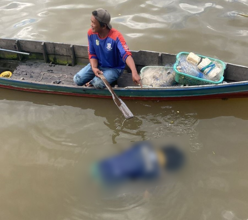 MENGAPUNG: Saksi Gunawan menahan jasad Wahyudinnor yang ia temukan di Sungai Martapura.