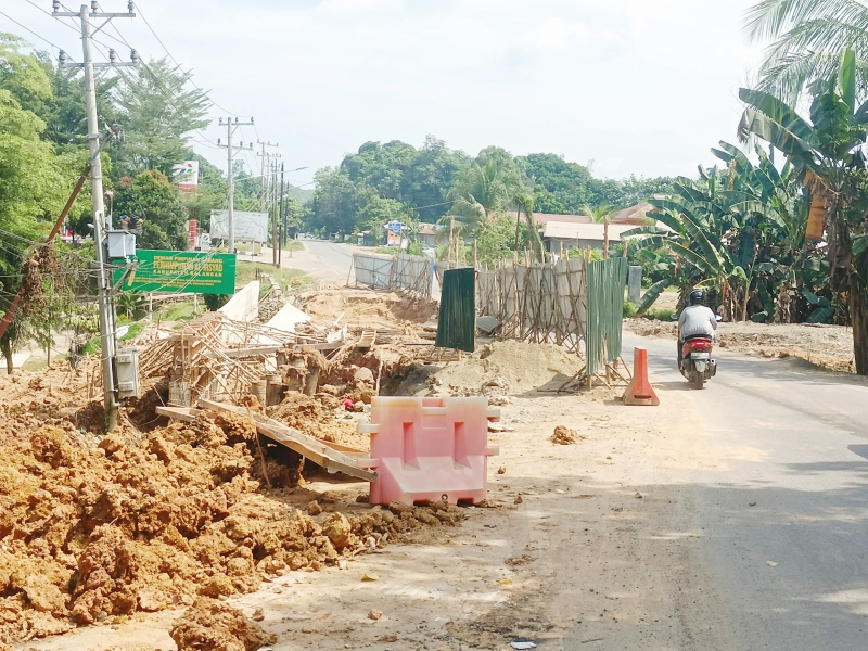 DIPERBAIKI: Pengguna jalan melintas di Kampung Minduin yang sedang dilakukan perbaikan jalan.
