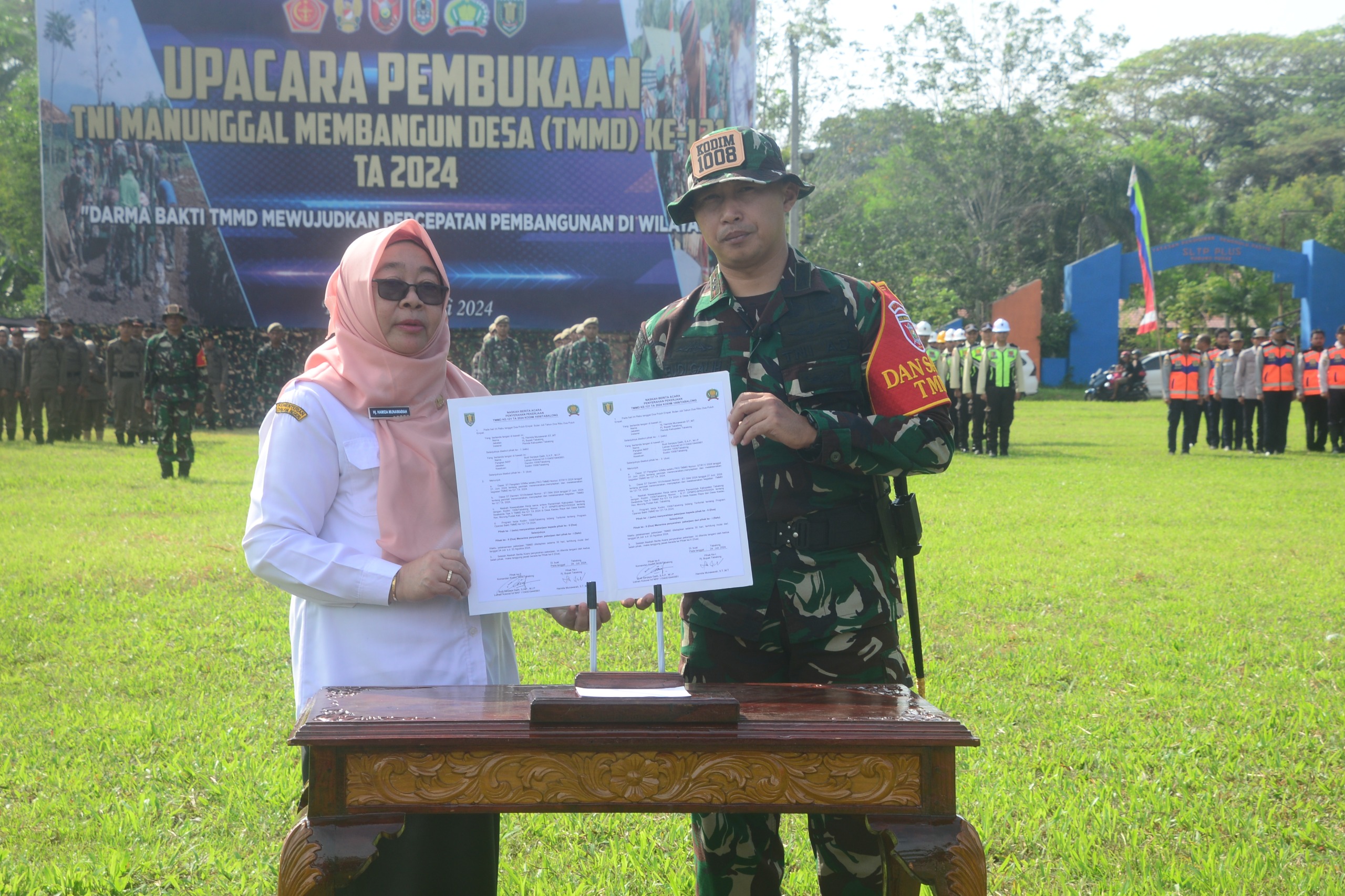 SERAH TERIMA PEKERJAAN : Pj Bupati Tabalong Hamida Munawarah dan Dandim 1008/Tabalong Letkol Inf Budi Sanjaya Galih memperlihatkan berkas kegiatan TMMD ke 121.