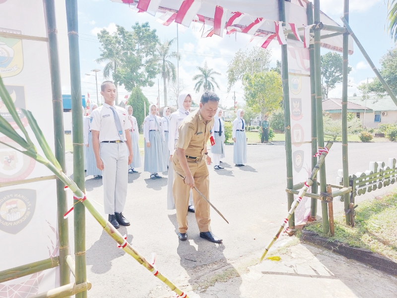 TRADISI: Kepala Kesbangpol Tala Muhammad Syahid memimpin tradisi tantingan 33 calon paskibraka Tala pada Senin (29/7/2024) siang. (Foto: Norsalim Yahya/Radar Banjarmasin).