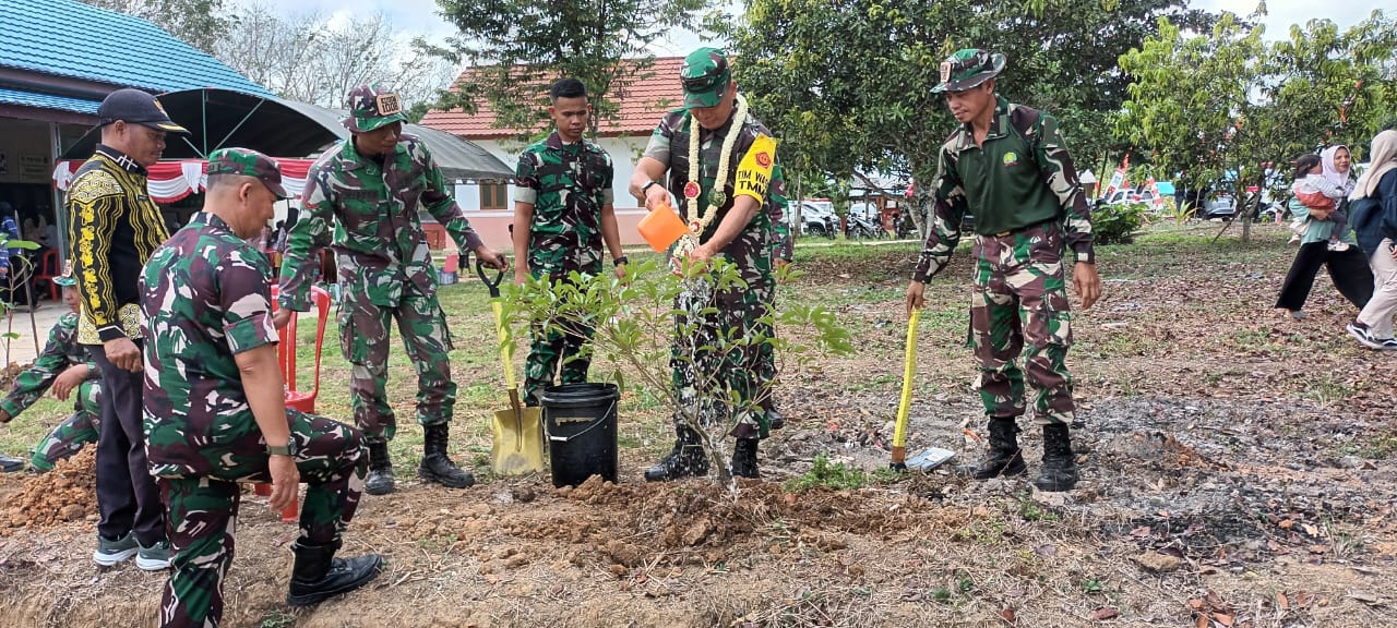 TANAM POHON : Ketua Tim Wasev Mabes TNI AD Mayjen TNI Jonathan Binsar Parluhutan menanam pohon di areal kantor Desa Kasiau Raya. Momen itu simbolis dilakukan dalam rangka menanam sejumlah pohon