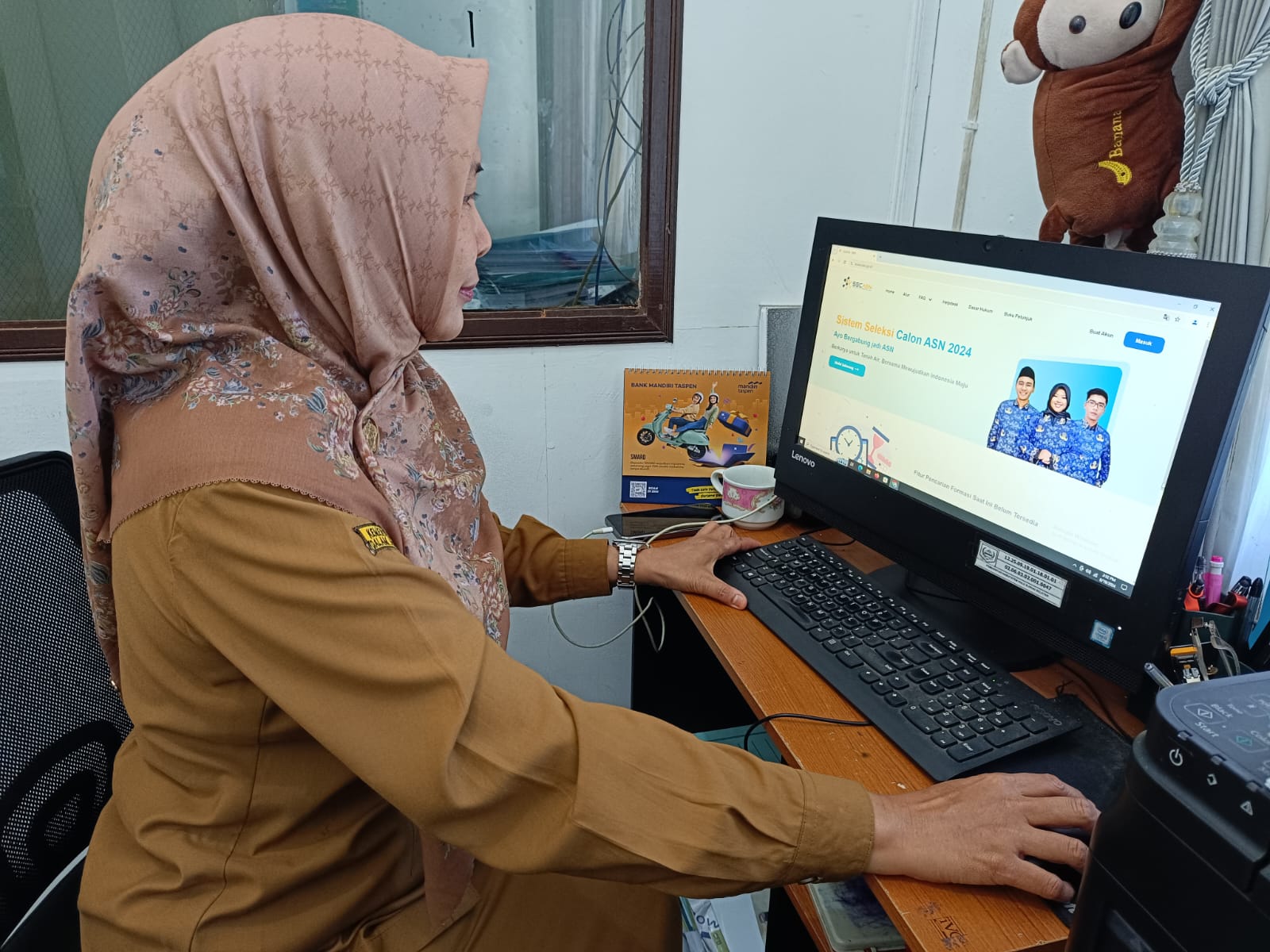 TUNJUKKAN : Kabid Administrasi, Data dan Informasi Kepegawaian ASN BKPSDM HSS Siti Mahmudah menunjukkan laman bagi yang ingin melamar. (Foto: Salahudin/Radar Banjarmasin)