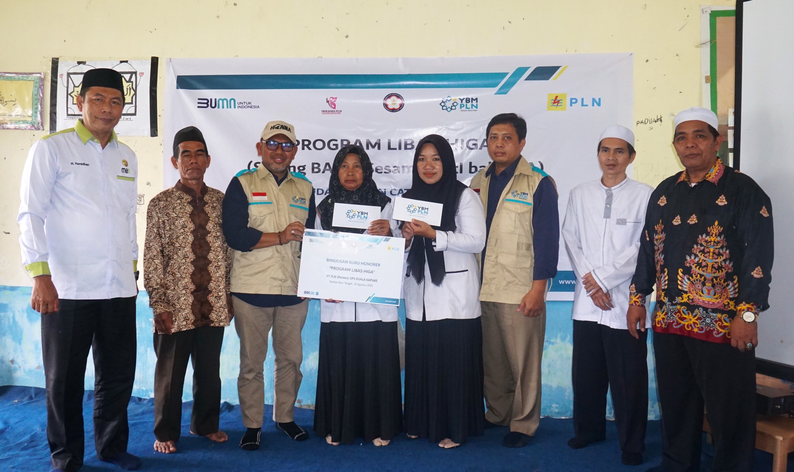 Simbolis penyerahan bantuan bingkisan kepada para guru pengajar di Madrasah Ibtidaiyah Swasta (MIS) Darul Huda yang berlokasi di Tamban Tengah, Kabupaten Kapuas, Kalimantan Tengah oleh Tim YBM PLN