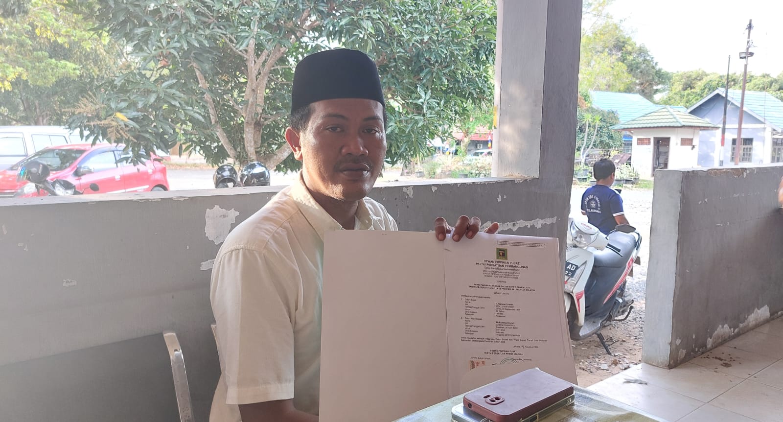 PERTANYAKAN : Sekretaris DPC PPP Tala Air Langga saat menunjukkan SK dukungan partainya ke pasangan Rahmat-Zazuli. (Foto : Norsalim Yahya/Radar Banjarmasin).