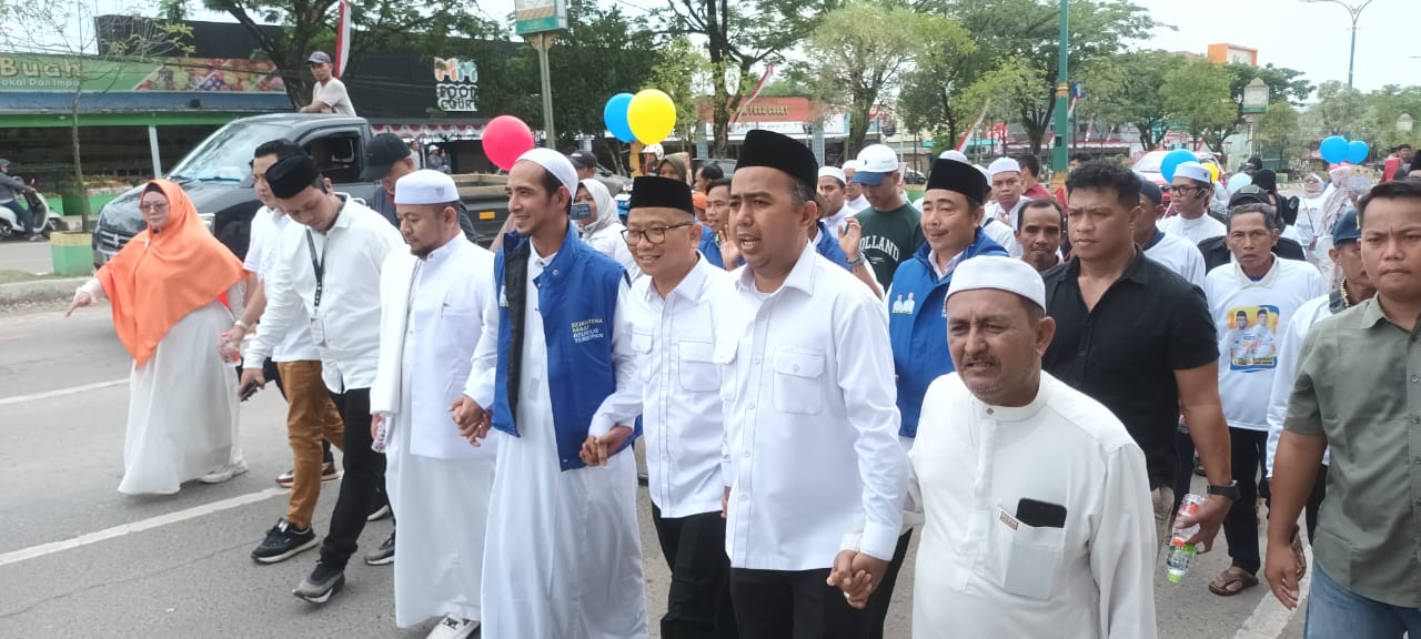 MENDAFTAR : Paslon Haji Fani dan Habib Taufan bersama simpatisannya berjalan kaki menuju kantor KPU Tabalong untuk mendaftar calon bupati dan wakil bupati Tabalong. Foto : Ibnu Dwi Wahyudi/ Radar Banj