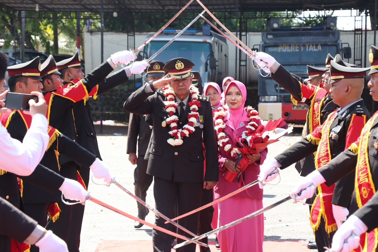 PENSIUN:Tradisi pedang pora mengiringi wisuda purna bakti tujuh personel Polres Tala, Senin (2/9/2024).(Foto:Humas Polres Tala)