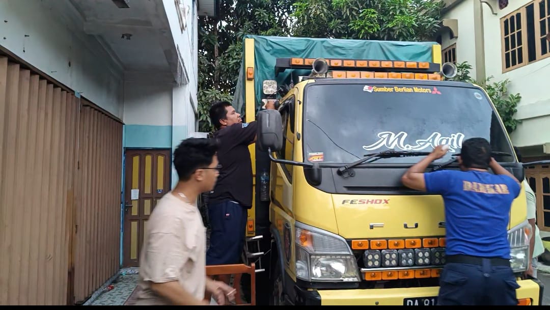 UPAYA: Tim Damkar HSU, saat melaksanakan upaya pertolongan pada balita laki-laki yang terjebak di dalam kabin truk milik ayahnya. (Foto: Damkar HSU/Radar Banjarmasin)