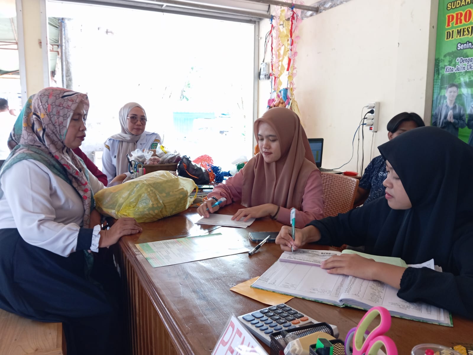 MENDAFTAR: Panitia pelaksana melayani peserta yang mendaftar baayun maulid. (Foto: Rasidi Fadli/Radar Banjarmasin)