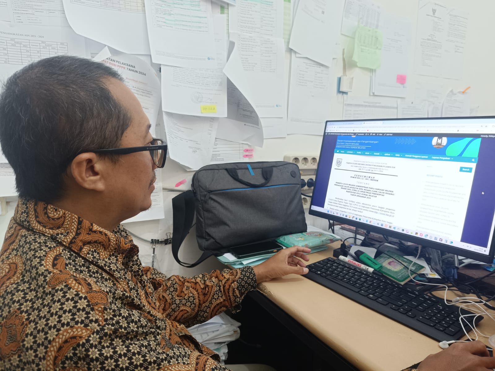 DATA PELAMAR:Pengelola Simpeg BKPSDM HSS Hidayatullah menunjukkan pengumuman hasil seleksi administrasi CPNS tahun 2024 Kabupaten HSS.(Foto:Salahudin/Radar Banjarmasin)