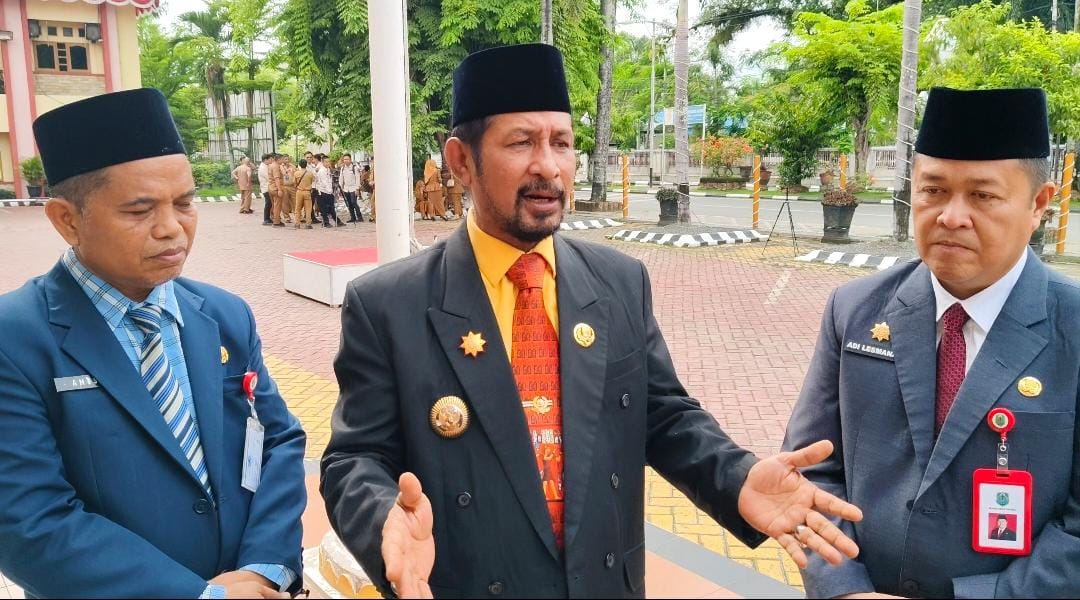 MENJELASKAN:Pj Bupati Kabupaten HSU, Zakly Asswan (tengah) didampingi Sekda, Adi Lesmana (kanan) dan Kadis PUPR HSU, Amos Silitonga menjelaskan kondisi titian viral di Desa Telaga Mas.(Foto: M.Akbar/R