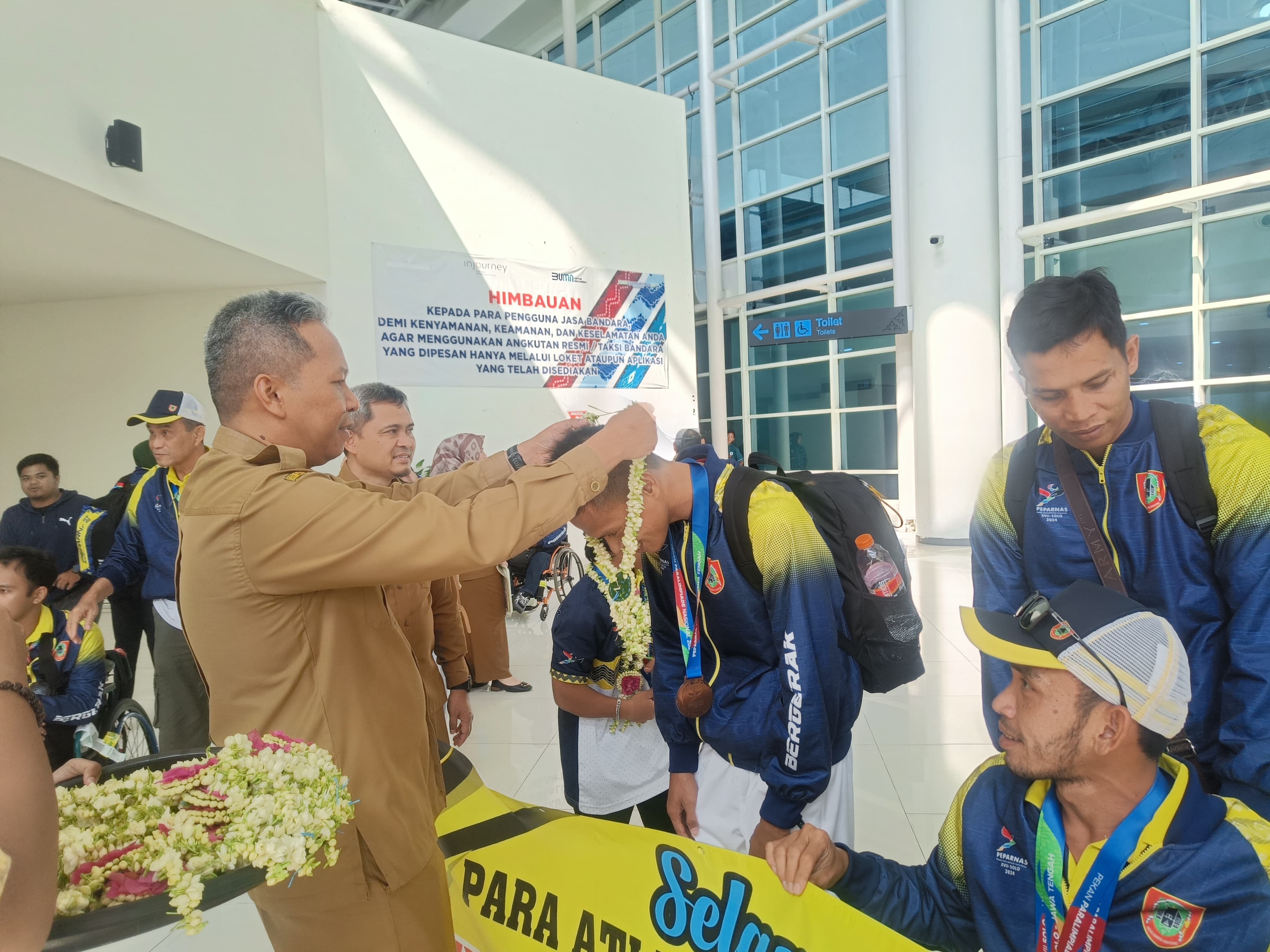DISAMBUT: Pengalungan bunga oleh Plt Kadispora Kalsel, Diauddin kepada kontingen Peparnas Kalsel.
