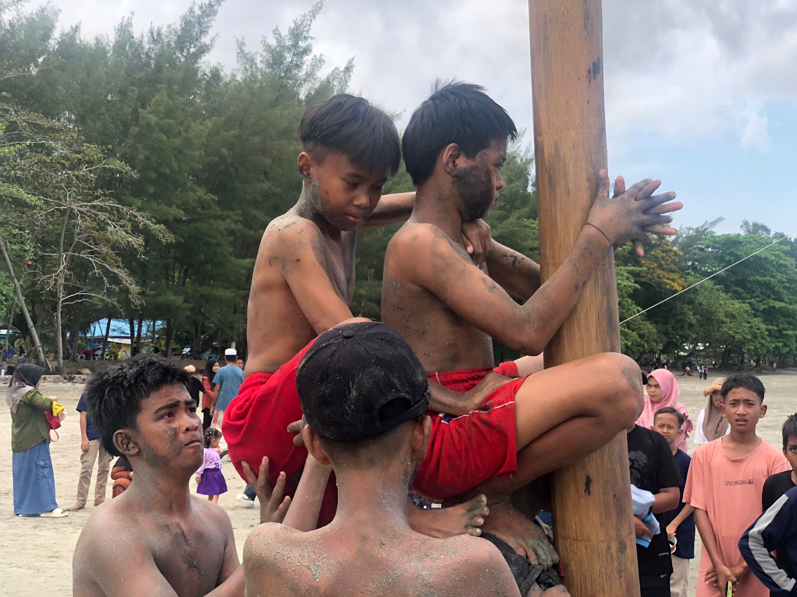 PERJUANGAN: Kegigihan anak anak Desa Gedambaan naik pinang di pinggir pantai. Foto: Jumain/ Radar Banjarmasin.