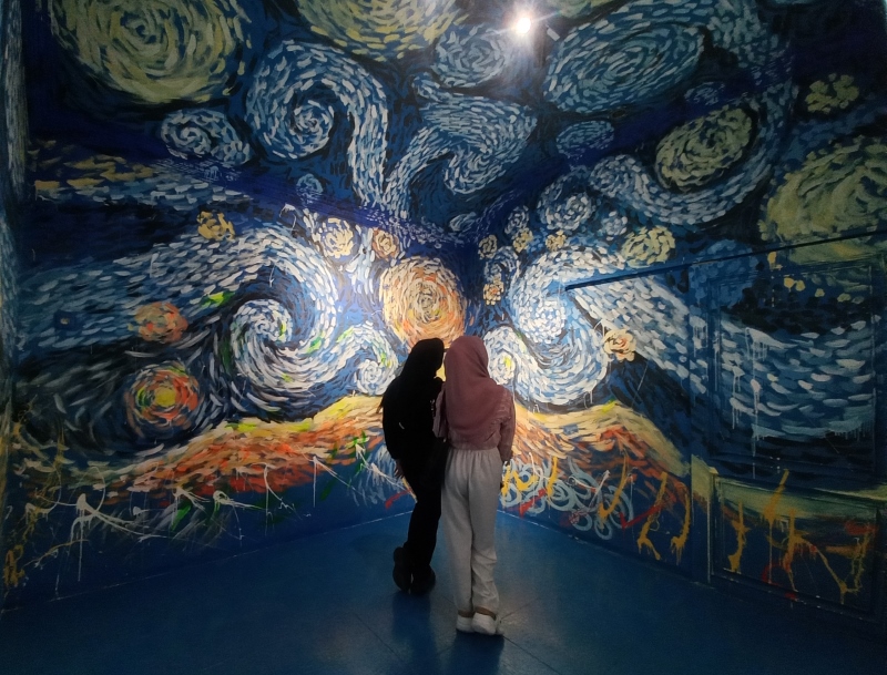 MARI BERKUNJUNG: Pengunjung Badrigallery menikmati dinding mural yang ditimpa permainan cahaya, Rabu (16/10) sore