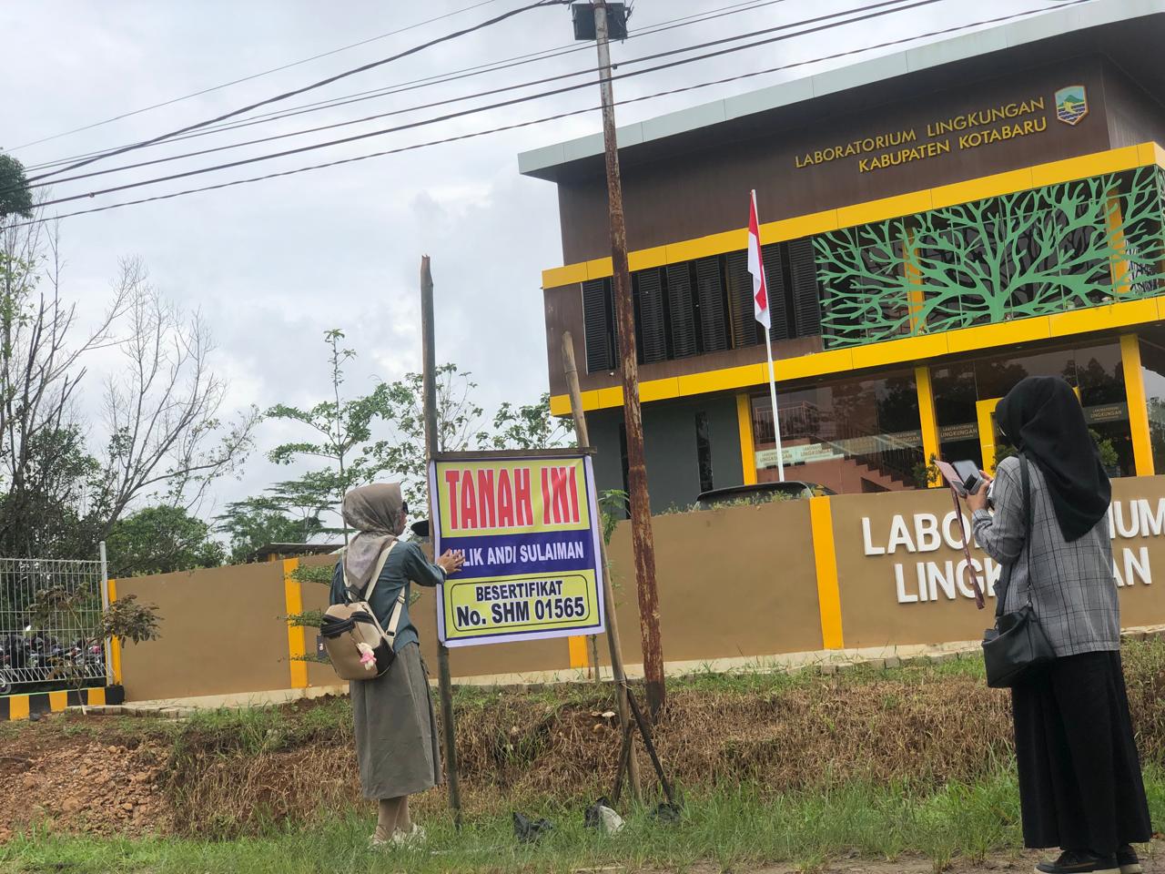 SENGKETA: Andi Mulfiani melakukan pematokan di depan Kantor Laboratorium Lingkungan Kabupaten Kotabaru yang ada di Desa Sebelimbingan.