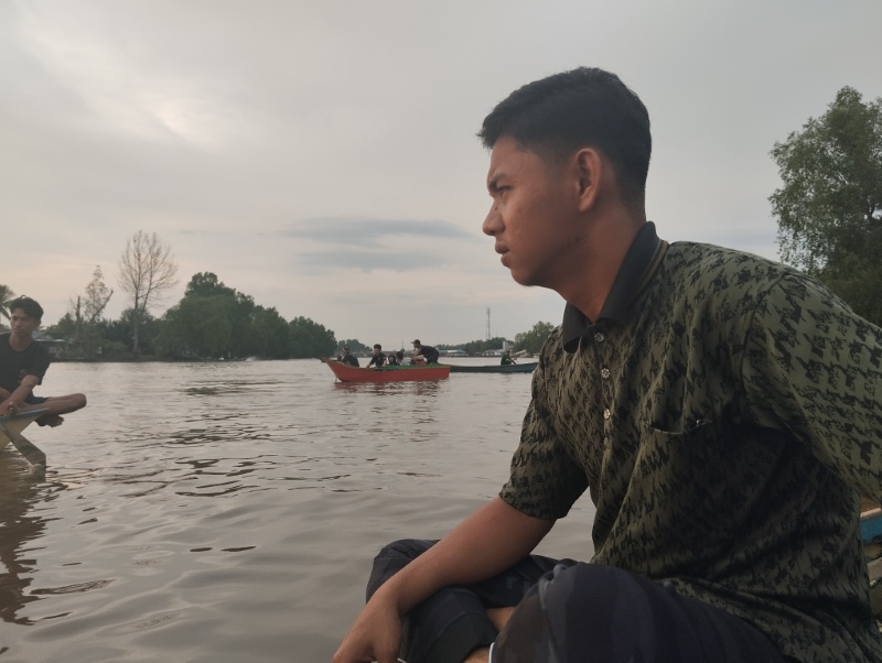 TERMENUNG: Firman hanya termenung melihat petugas gabungan mencari jasad temannya yang tenggelam di Sungai Aluh-Aluh Besar, Kecamatan Aluh-Aluh, Kabupaten Banjar.