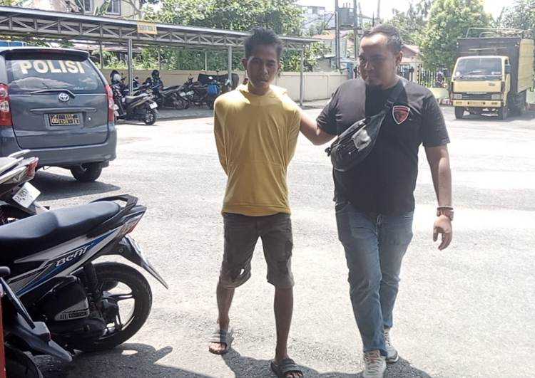 PEMALAK: Diky (25) digiring polisi ke markas Polsek Banjarmasin Tengah usai ditangkap di Jalan Teluk Tiram Darat.