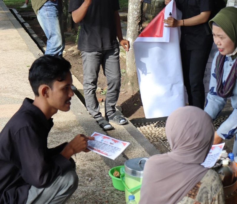 MEMBAGI: Anggota Forum Demokrasi Milenial (FDM) Kabupaten Banjar, membagi selebaran tentang ajakan menciptakan Pemilu Damai kepada pengunjung warga Martapura, Minggu (17/11).