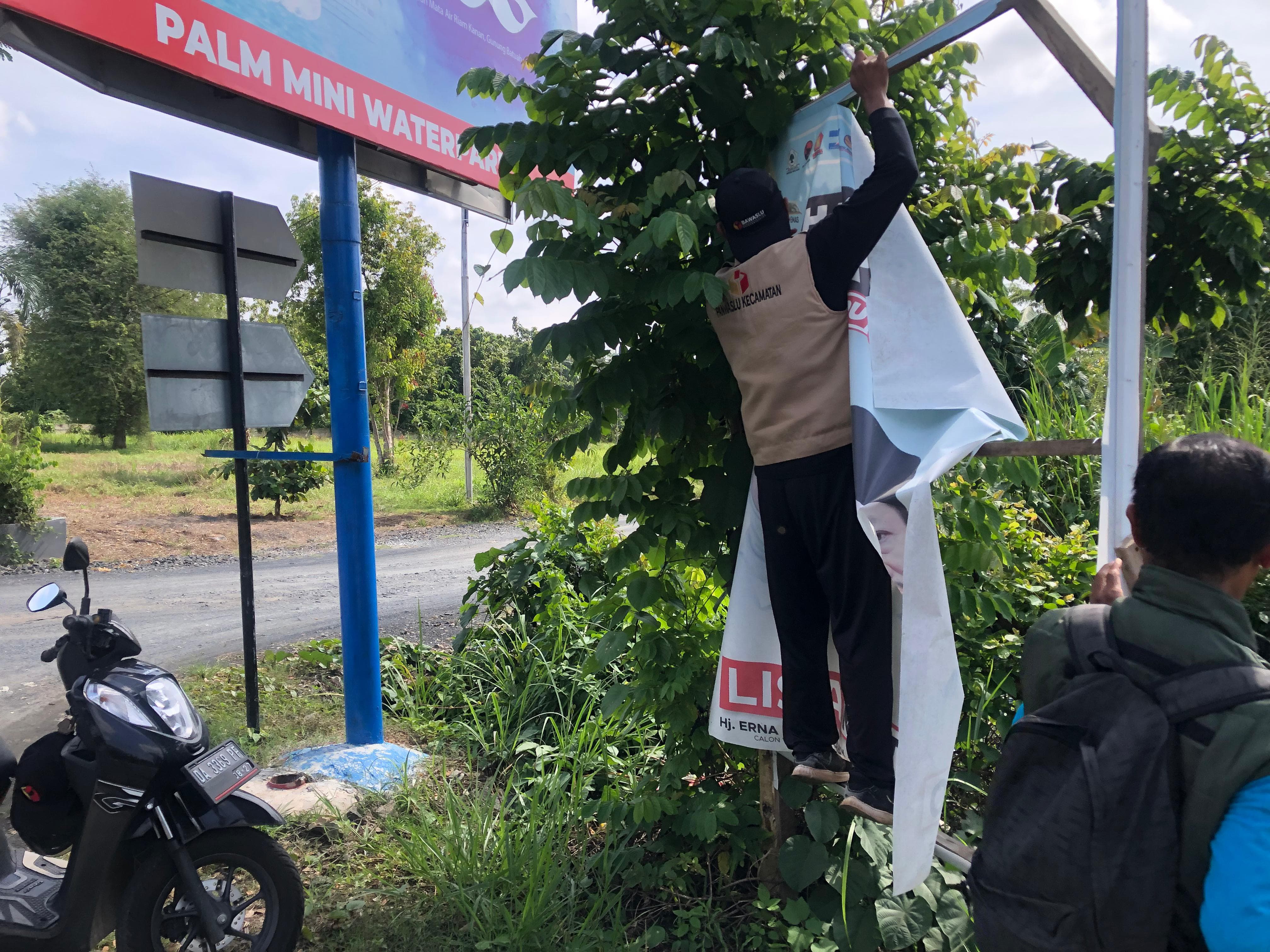DITURUNKAN: Sejumlah APK dan APS ditertibkan oleh tim terpadu Bawaslu dan KPU di Kecamatan Landasan Ulin Kota Banjarbaru, (SHEILLA FARAZELA/RADAR BANJARMASIN)